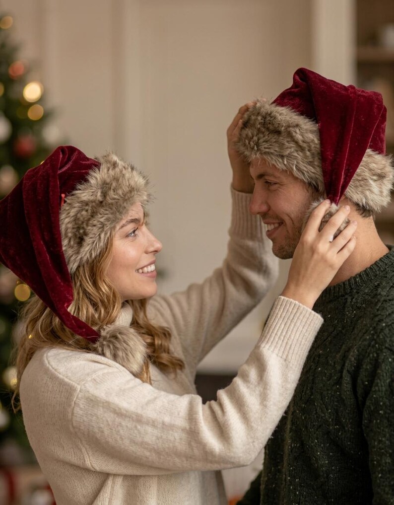 Puede incluir: Dos gorros de Pap&aacute; Noel a juego hechos de tela de terciopelo rojo oscuro. Cada gorro presenta un borde grueso de piel sint&eacute;tica texturizada en la base y un pomp&oacute;n de piel sint&eacute;tica a juego en la punta, creando un accesorio festivo.