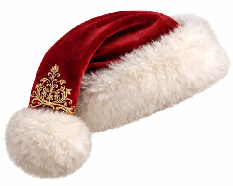 May include: A deep red velvet hat featuring a thick, fluffy white faux fur trim and a matching white pom-pom at the tip. The red velvet fabric is decorated with intricate gold thread embroidery in a floral pattern near the pom-pom base.