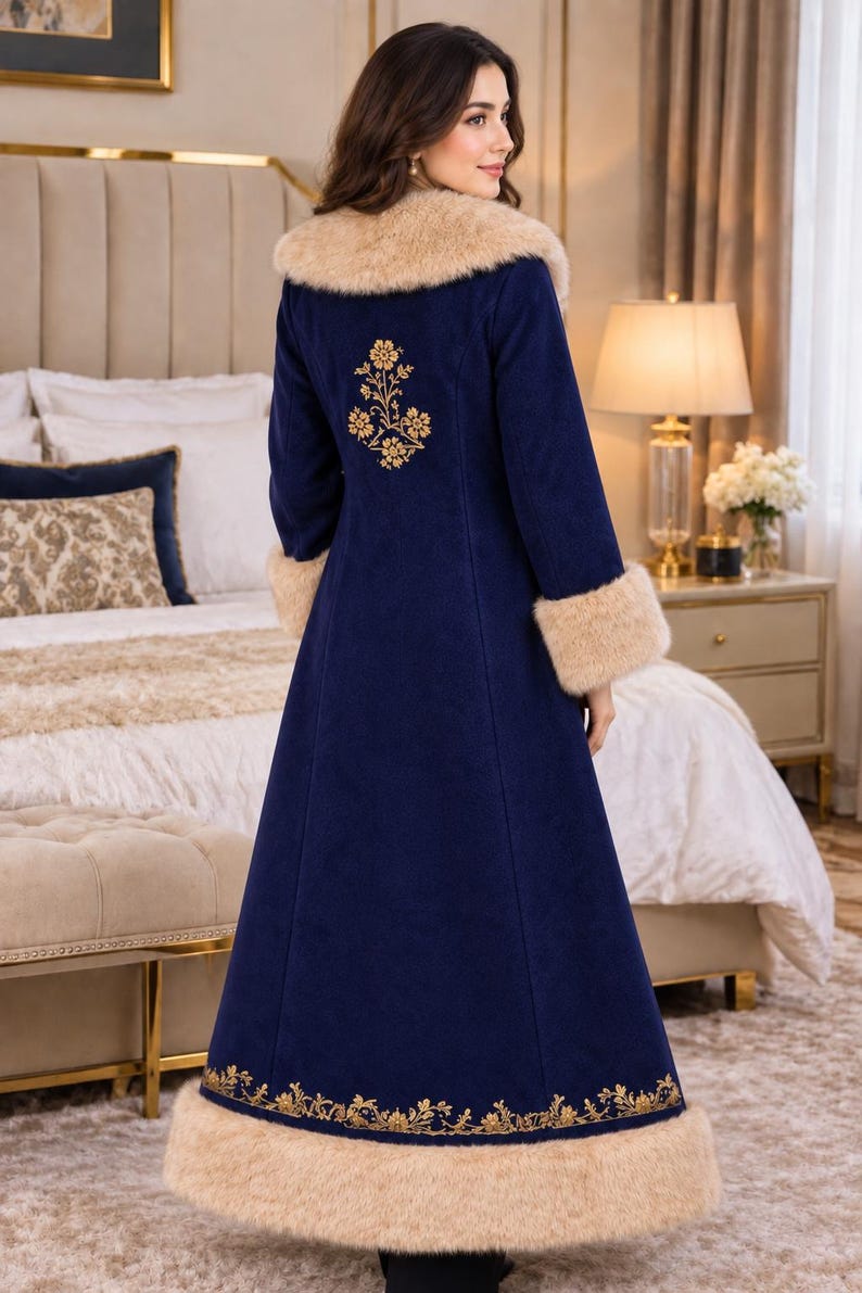 May include: A long navy blue coat featuring a beige faux fur collar and cuffs. The coat is decorated with gold floral embroidery on the upper back and along the bottom hem. The garment has a structured fit and reaches down to the lower legs.