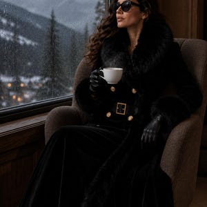 May include: A long black coat featuring a thick faux fur collar and cuffs, a belted waist with a gold-toned buckle, and double-breasted gold buttons. The garment is worn with black leather gloves and dark sunglasses while holding a white cup.