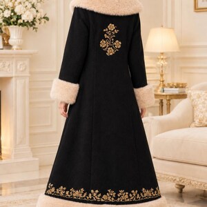 Pu&ograve; includere: Un lungo cappotto nero con colletto e polsini in pelliccia sintetica beige. Il retro del cappotto &egrave; decorato con un ricamo floreale dorato tra le spalle e un bordo floreale dorato abbinato lungo l'orlo inferiore.