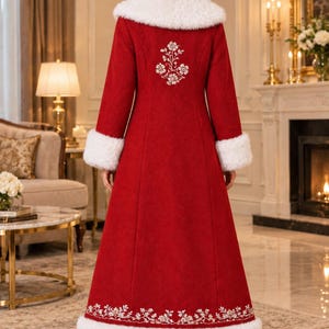Pu&ograve; includere: Un cappotto rosso lungo fino ai piedi con colletto e polsini in pelliccia sintetica bianca. Il retro del cappotto &egrave; decorato con ricami floreali bianchi tra le spalle e un bordo floreale abbinato lungo l'orlo inferiore sopra la pelliccia.