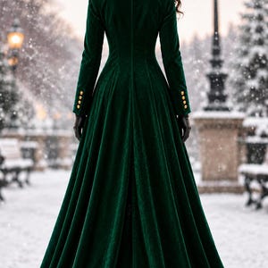 May include: A floor-length dark green velvet coat featuring long sleeves with four gold buttons on each cuff, a structured collar with gold floral embroidery, and a flared skirt. The garment is shown from the back, displaying a fitted bodice.