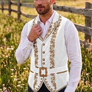 May include: A white vest featuring intricate gold floral embroidery along the lapels and front panels. The garment includes a row of four round gold buttons and a matching gold buckle at the waist, worn over a long-sleeved white button-down shirt.