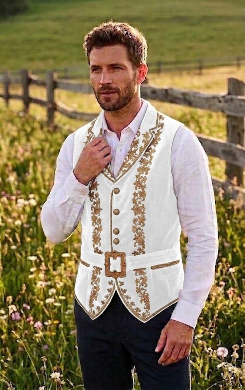 May include: A white vest featuring intricate gold floral embroidery along the lapels and front panels. The garment includes a row of four round gold buttons and a matching gold buckle at the waist, worn over a long-sleeved white button-down shirt.