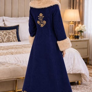 Pu&ograve; includere: Un cappotto lungo blu scuro con colletto e polsini in pelliccia sintetica beige. Il cappotto &egrave; decorato con ricami floreali dorati sulla parte superiore della schiena e lungo l'orlo inferiore, rifinito con un'ampia fascia di pelliccia sintetica.
