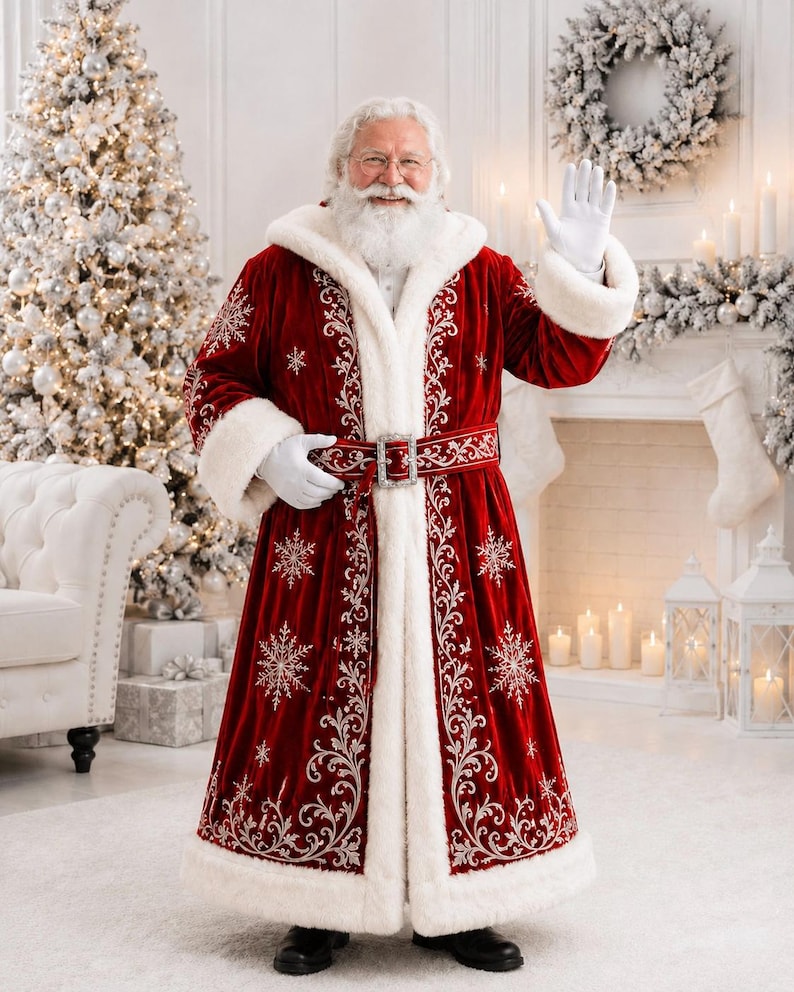 May include: A floor-length red velvet coat with a white faux fur hood, cuffs, and hem. The coat features intricate silver embroidery in floral and snowflake patterns, a matching belt with a silver buckle, and white gloves.