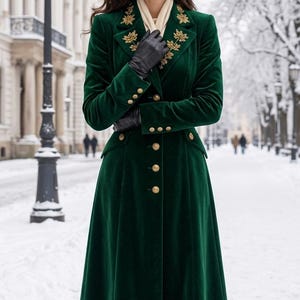 May include: A long, dark green velvet coat featuring gold-toned buttons down the front and on the cuffs, with intricate gold embroidery on the lapels. The coat is worn with black leather gloves and dark brown leather knee-high boots.