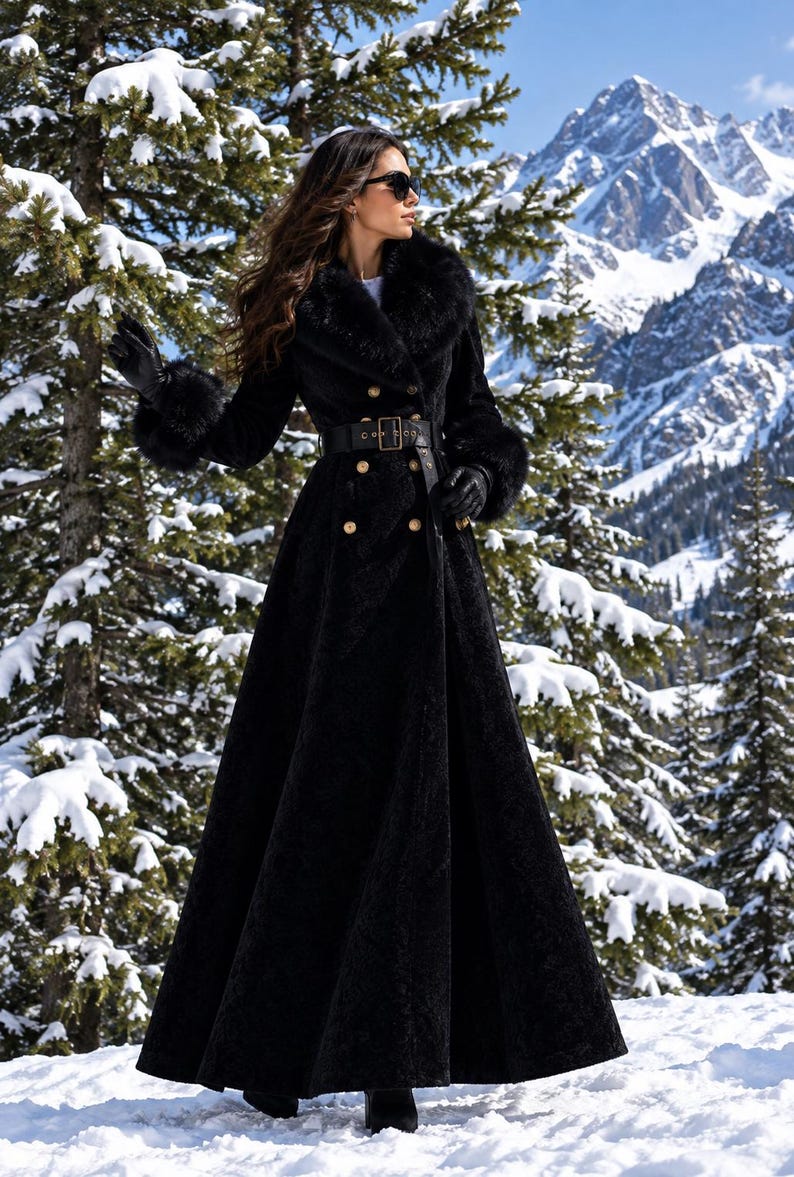 May include: A long black coat featuring a wide faux fur collar and matching faux fur cuffs on the sleeves. The coat includes a double-breasted button front closure, a wide black belt with a rectangular buckle at the waist, and a full-length skirt.