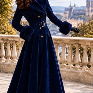 May include: A floor-length navy blue velvet coat featuring a wide collar, long sleeves with fur cuffs, and a belted waist with a gold buckle. The coat is adorned with gold buttons along the front and at the waist, and it has a flared skirt silhouette.