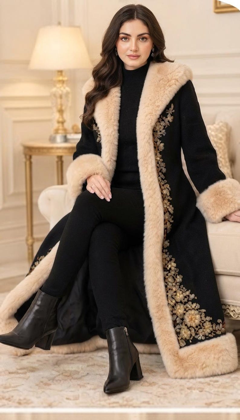 Pu&ograve; includere: Un lungo cappotto nero caratterizzato da un folto bordo in pelliccia sintetica beige lungo il colletto, l'apertura frontale e i polsini. Il cappotto &egrave; decorato con intricati ricami floreali color oro e bronzo sui pannelli anteriori.
