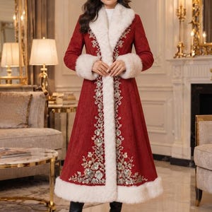 May include: A long, deep red coat featuring a thick white faux fur trim along the collar, cuffs, and hem. The front of the coat is decorated with intricate silver and white floral embroidery that runs vertically along the center opening.
