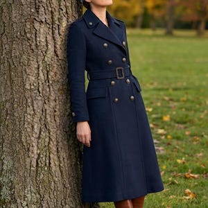 May include: A navy blue double-breasted long coat featuring a notched lapel, shoulder epaulets, and a matching waist belt with a rectangular buckle. The coat has two rows of metallic buttons and two flap pockets at the waist, paired with brown boots.