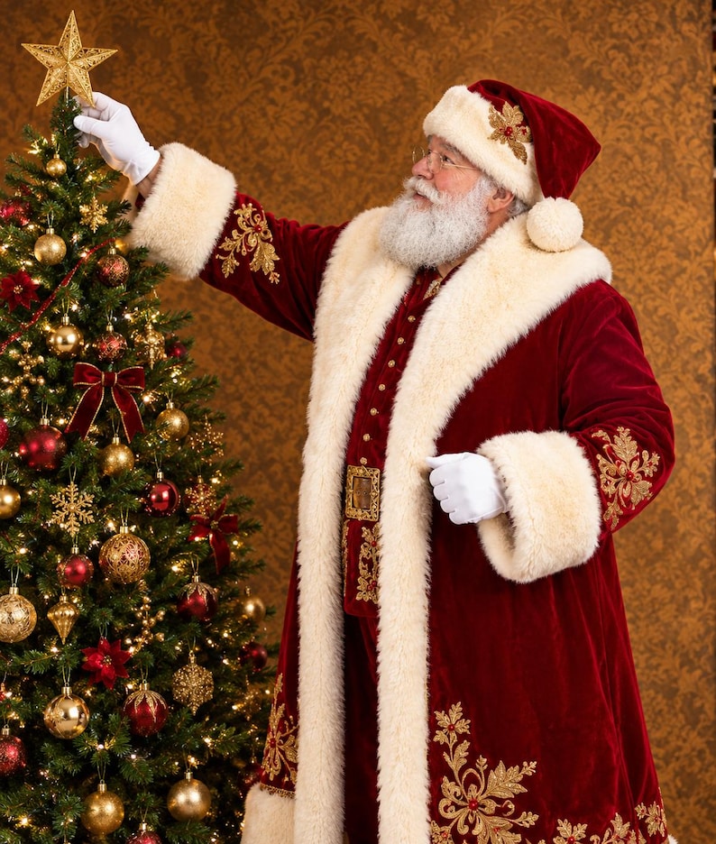 May include: A figure dressed in a deep red velvet coat and matching hat with thick white faux fur trim, gold embroidery, and white gloves, placing a gold star on top of a Christmas tree decorated with gold and red ornaments and lights.