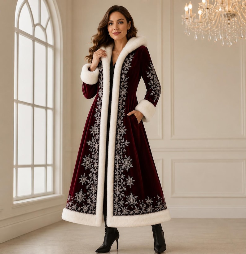 May include: A long, deep burgundy velvet coat featuring a white faux fur trim along the hood, cuffs, and hem. The coat is decorated with intricate silver snowflake embroidery patterns along the front opening and sleeves, and includes side pockets.