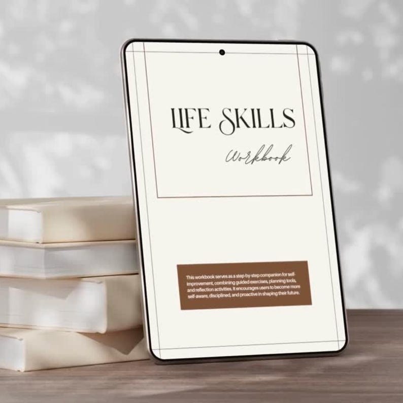 a tablet or e-reader with the title "LIFE SKILLS WORKBOOK" on its cover, placed on top of a stack of books.