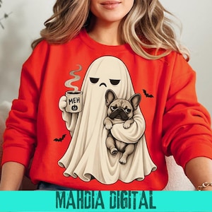 Op de afbeelding: Een feloranje sweatshirt met lange mouwen en een afbeelding van een witte geest die een dampende mok vasthoudt met het opschrift MEH en een klein pompoenicoontje. De geest houdt ook een beige Franse bulldog vast. Twee kleine zwarte vleermuizen vliegen eromheen.