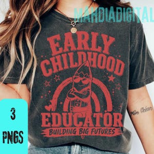 Peut inclure: T-shirt gris foncé avec un motif rouge indiquant "EARLY CHILDHOOD EDUCATOR" avec un personnage de crayon portant des lunettes de soleil. Le texte "BUILDING BIG FUTURES" est en dessous. Le t-shirt a également le texte "3 PNGS" dans un encadré bleu.