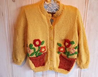 Girls yellow pure wool 8 ply Cardigan with rust flower pot pockets and  colourful flowers and leaves, size 2 years