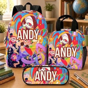 Op de afbeelding: Een rugzak, een lunchtas en een etui, allemaal voorzien van een levendige, veelkleurige cartoonprint met diverse personages en de naam ANDY in grote witte hoofdletters in het midden van elk item.