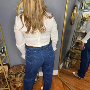 May include: A handmade, wooden serving tray with a natural finish. The tray features a rectangular shape with rounded corners and raised edges. It is designed with two handles for easy carrying. The tray measures approximately 18 inches long and 12 inches wide.