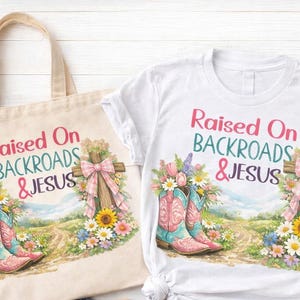 May include: A white t-shirt and a beige tote bag with the text "Raised On Backroads & Jesus". Both items feature a colorful graphic of cowboy boots, a cross, and flowers. The design has a country theme.