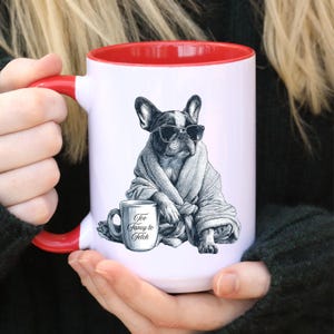 May include: White ceramic mug with a red interior and handle. The mug features a black and white illustration of a French Bulldog wearing sunglasses and a robe, with a smaller mug that says "Too Fancy to Fetch."
