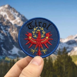 May include: A set of three ceramic mugs with a speckled, matte finish. The mugs are in shades of cream, light gray, and dark gray. Each mug has a simple, minimalist design and a rounded handle.