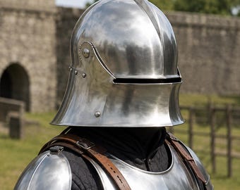 May include: A polished steel sallet helmet with a narrow horizontal visor slit, paired with a matching steel breastplate and articulated shoulder pauldrons. The armor is worn over a black quilted gambeson with brown leather straps and metal buckles.