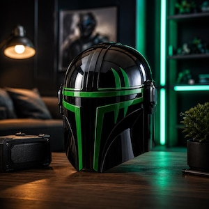 Puede incluir: Un casco negro con detalles verdes, con un acabado brillante y un dise&ntilde;o que recuerda a un guerrero futurista. El casco se exhibe sobre una superficie de madera, con un altavoz y una peque&ntilde;a planta cerca.