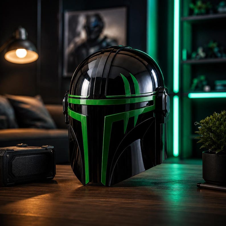 Puede incluir: Un casco negro con detalles verdes, con un acabado brillante y un dise&ntilde;o que recuerda a un guerrero futurista. El casco se exhibe sobre una superficie de madera, con un altavoz y una peque&ntilde;a planta cerca.