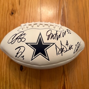 Dak Prescott, George Pickens, CeeDee Lamb, Caleb Downs och Javonte Williams signerade fotbollar med logotyp och äkthetsintyg.