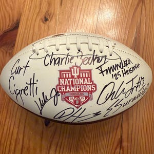 Fernando Mendoza, equipo del campeonato Indiana Hoosiers, firmó un balón de fútbol con COA