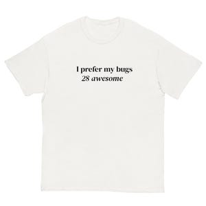 May include: White t-shirt featuring the black text: "I prefer my bugs 28 awesome". The shirt has a crew neck and short sleeves. The material looks like a soft cotton blend.