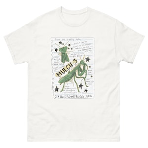 Può includere: Una t-shirt bianca con la grafica di una pagina di taccuino e una mantide religiosa verde disegnata a mano. Il testo include "MULCH 3", "Green and Slightly Spiky", "Weight: 2.8g", "Height: 23cm", "28AWESOMEBUGS.ORG" e varie note scritte a mano.