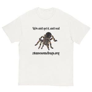 May include: White t-shirt with a tarantula illustration in brown and black. The shirt has the text "We ain't get it, ain't real" and "28awesomebugs.org" in a gothic font, suitable for insect enthusiasts.