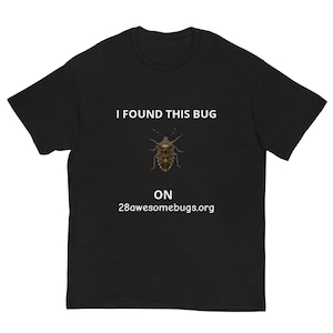 Könnte beinhalten: Schwarzes T-Shirt mit dem Text "I FOUND THIS BUG" über einer detaillierten Insektenillustration. Darunter steht "ON 28awesomebugs.org". Ein lässiges Kleidungsstück.