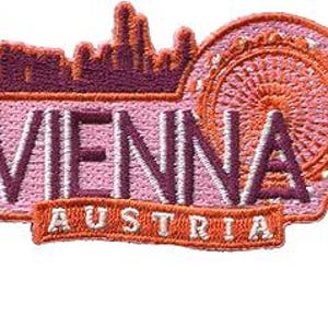 May include: Embroidered patch featuring the city name "VIENNA" in dark purple letters over a light pink background. The patch includes an orange Ferris wheel and a cityscape silhouette, with "AUSTRIA" in orange below.