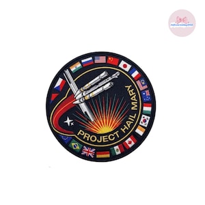 May include: A white ceramic mug with a black handle and the text "But First, Coffee" in a black, bold font. The mug is on a white surface.