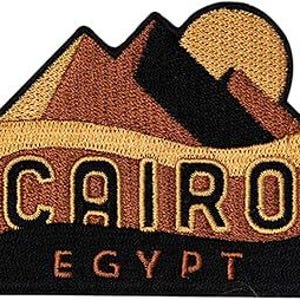 May include: Embroidered patch featuring a stylized mountain range and sun design with the word "CAIRO" in large letters and "EGYPT" below. The patch uses shades of brown, black, and gold.