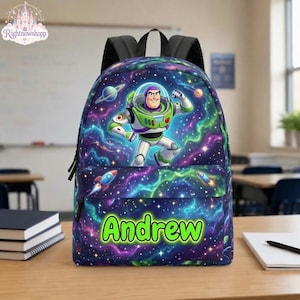 Op de afbeelding: Een rugzak met een ruimte-thema print met sterren, nevels en planeten. Het ontwerp bevat een afbeelding van het personage Buzz Lightyear en de naam Andrew in felgroene letters op het voorvak, voorzien van zwarte schouderbanden.