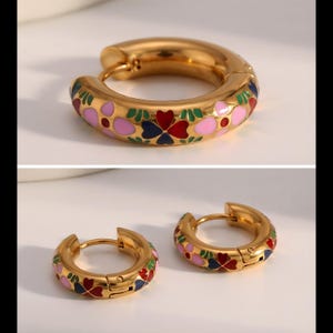 Two views of a pair of thick gold hoop earrings with pink, blue, red, and green enamel floral designs, one close-up and one showing the pair.