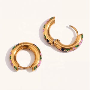 Two thick gold hoop earrings with pink, blue, red, and green enamel floral designs, one open and one closed.