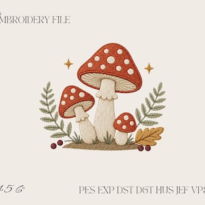 Pode incluir: Um design de ficheiro de bordado com três cogumelos vermelhos de pintas brancas, folhas de feto verdes e uma folha de carvalho dourada. O texto diz EMBROIDERY FILE, 4 5 6, e PES EXP DST DGT HUS JEF VP3 XXX. Duas pequenas estrelas douradas.