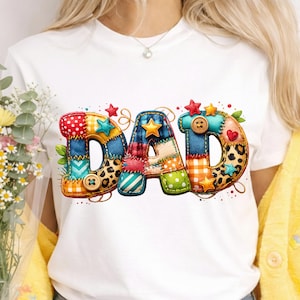 May include: White t-shirt featuring the word "DAD" in a colorful, patchwork design. The letters are adorned with stars, buttons, and various patterns, including polka dots, leopard print, and plaid. A charming and festive design.