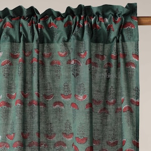 Könnte beinhalten: Grüner Vorhang mit einem sich wiederholenden Muster aus roten und schwarzen floralen Designs. Der Vorhang hat eine geraffte Oberseite, und der Stoff scheint eine leichte Baumwolle oder Leinen zu sein. Die Gesamtästhetik ist böhmisch und würde zu einem Wohn- oder Schlafzimmer passen.