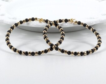 Große Ohrringe Schwarze Swarovski Perlen und goldfarbene Glasperlen