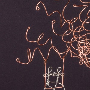 May include: A wire sculpture of a tree with two figures on a swing. The tree is made of copper wire and the figures are made of silver wire.