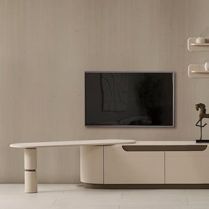 May include: A contemporary living room arrangement with a wall-mounted TV. A cream-coloured cabinet with a dark brown base and a matching coffee table are positioned below. Decorative shelves and a bronze horse sculpture complete the decor, creating a stylish space.