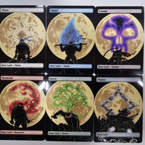 Op de afbeelding: Zes rechthoekige ruilkaarten met silhouetten van Teenage Mutant Ninja Turtles tegen een volle maan achtergrond. Elke kaart toont een uniek landtype symbool: Plains, Island, Swamp, Mountain, Forest en Wastes, met bijbehorende tekstlabels.